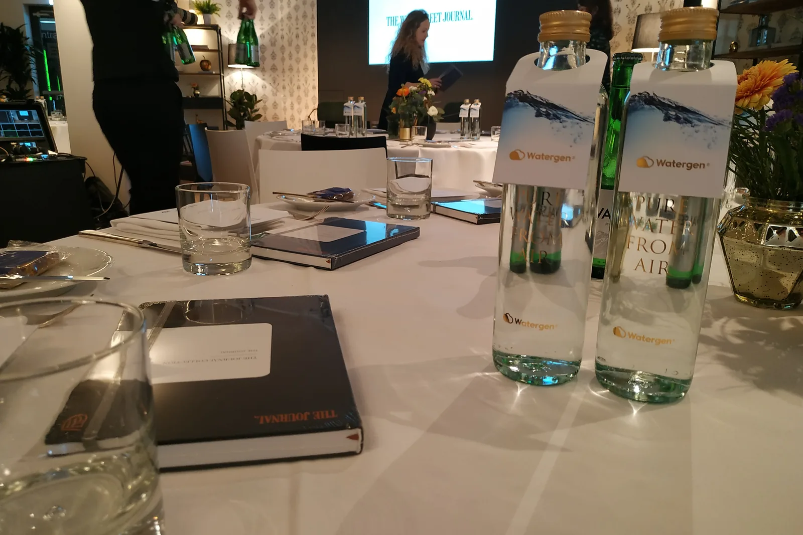 A table set for a Wall Street Journal session, with Watergen bottles labelled “Pure water from air”