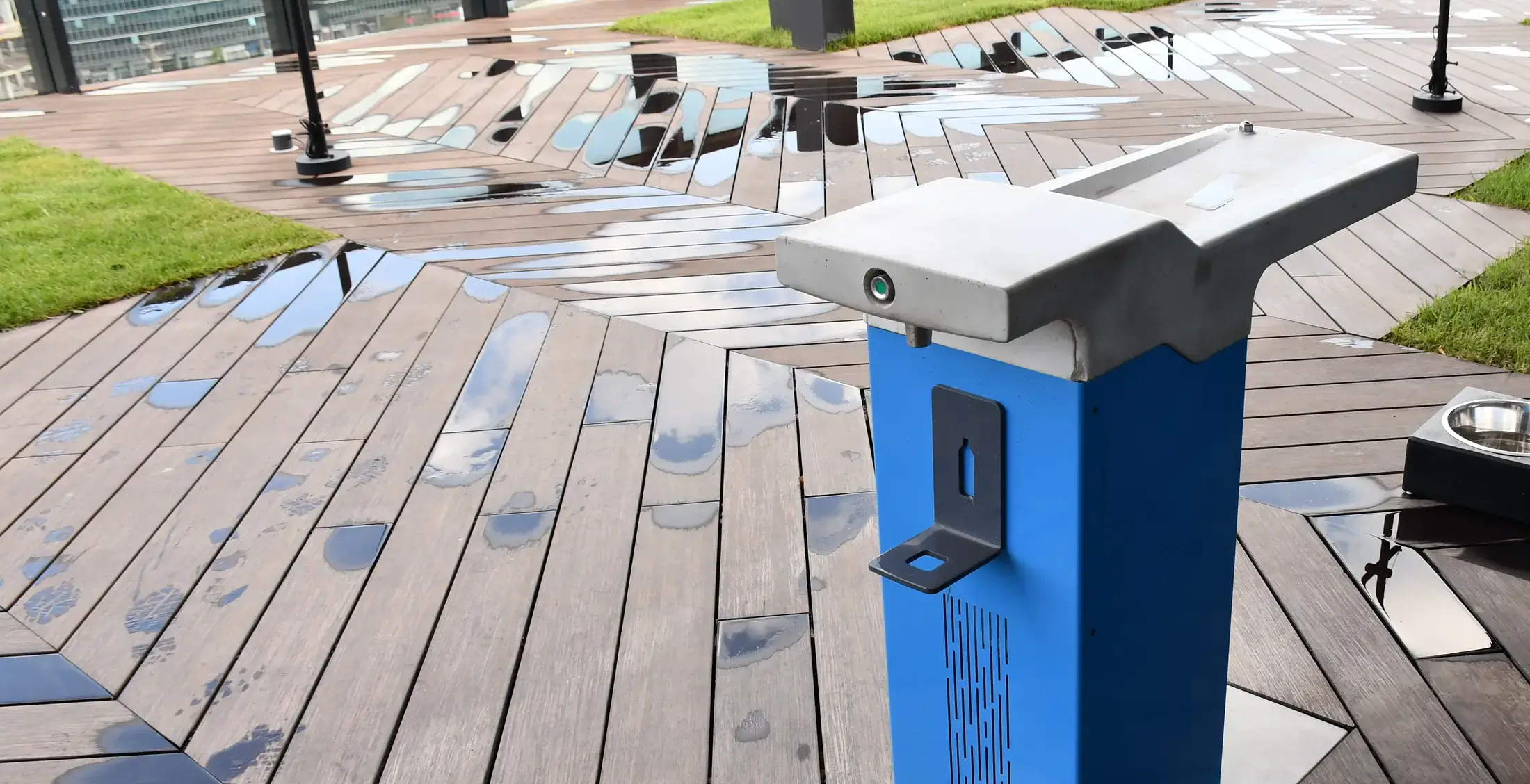 A Watergen drinking fountain on the campus roof deck, the city beyond