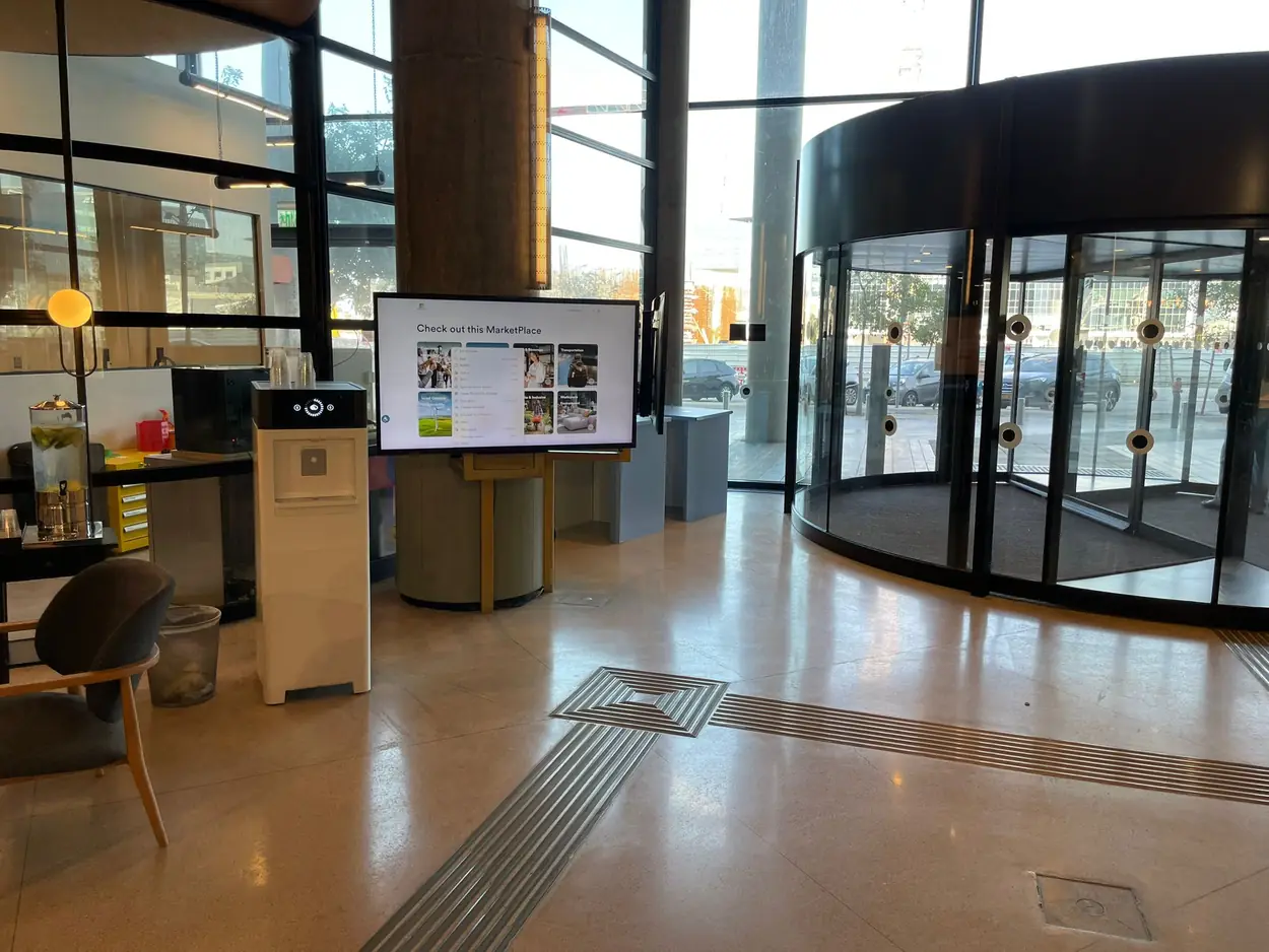 The Microsoft green campus lobby, with a Watergen drinking water dispenser beside the revolving entrance doors