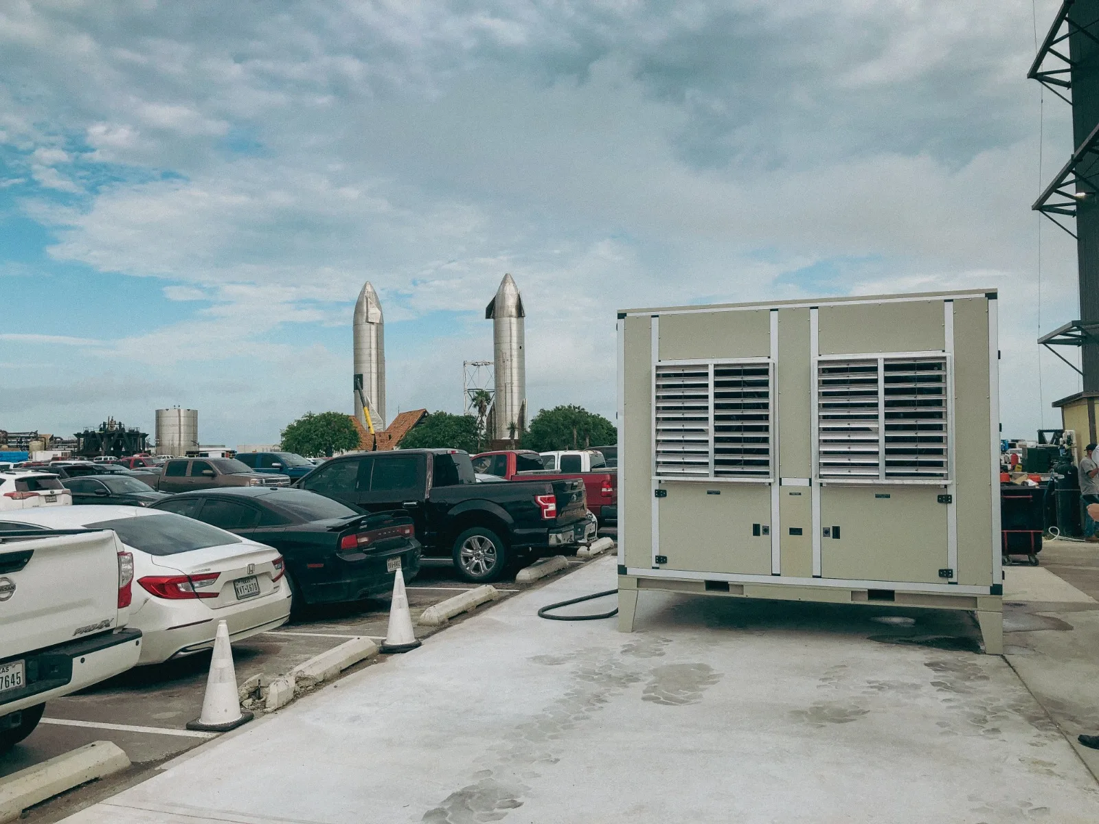 A Watergen unit at SpaceX Starbase with two Starship vehicles on the horizon