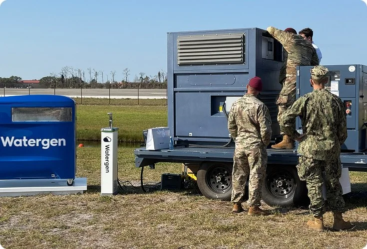Service members setting up a trailer-mounted Watergen unit during hurricane relief