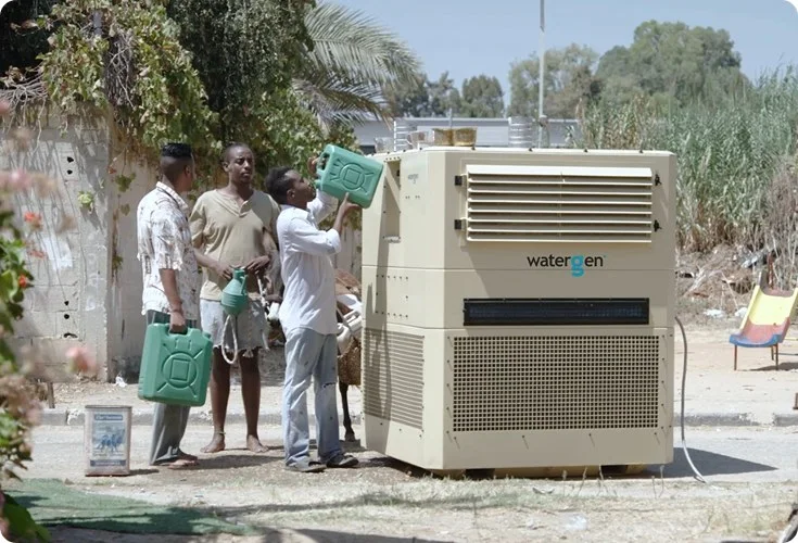 People filling containers from a Watergen unit at a relief deployment