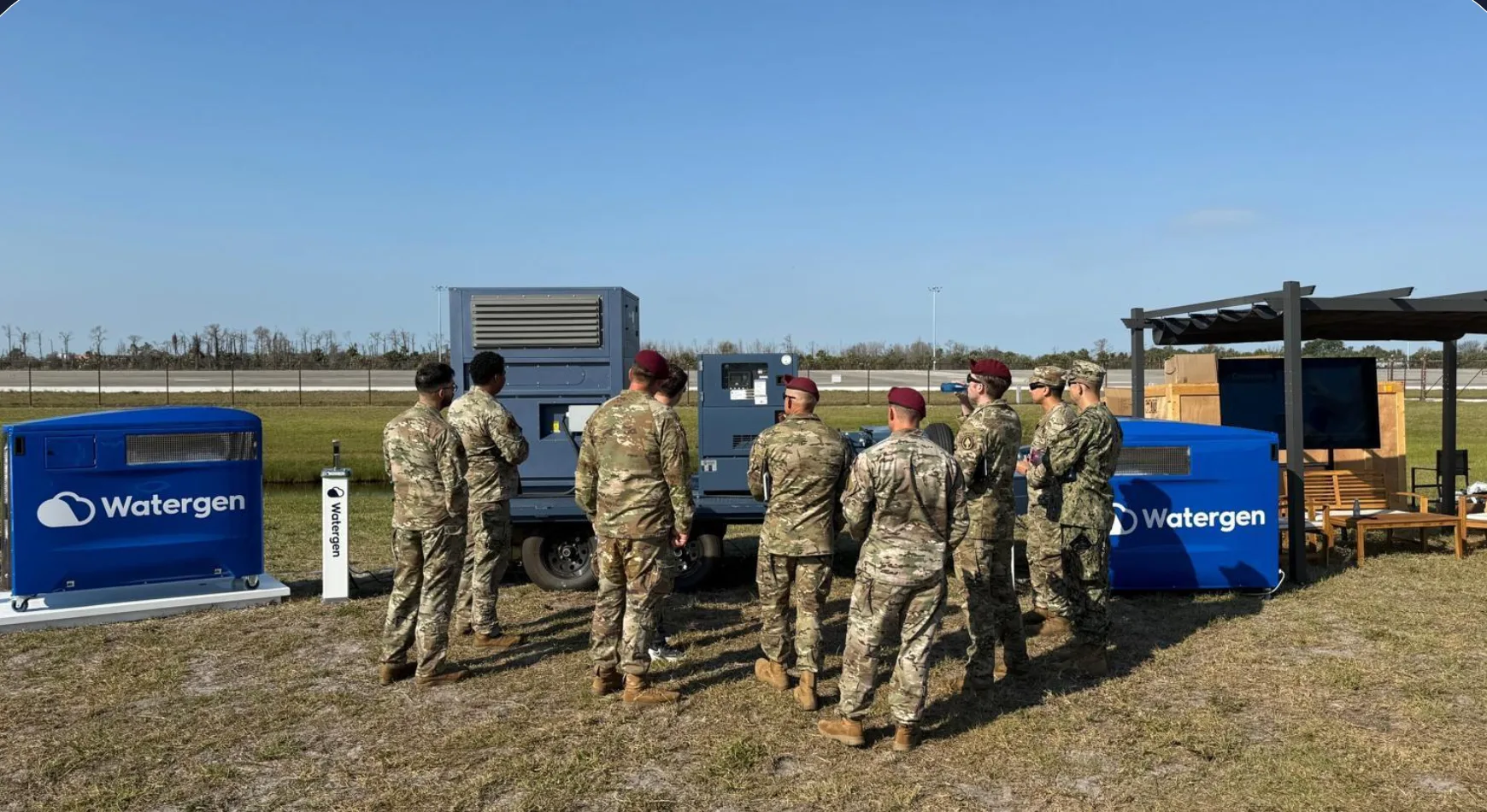 Military personnel at a field demonstration between two Watergen atmospheric water generators