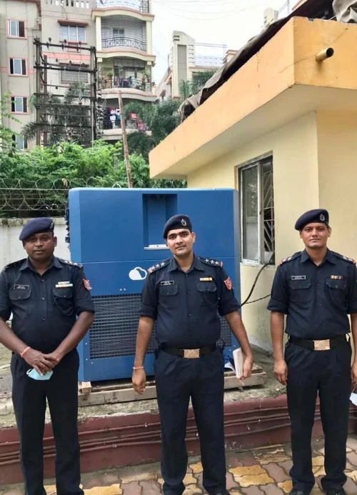 Three officers in front of a Watergen unit installed beside a guard post
