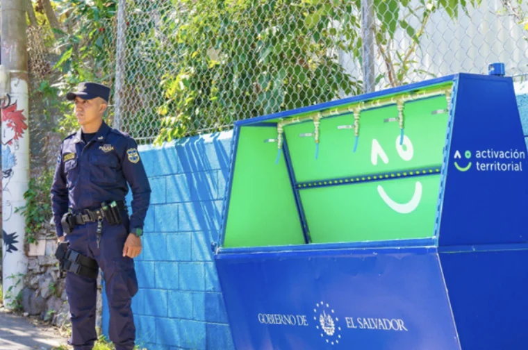 A police officer beside a public multi-tap water point of the government of El Salvador